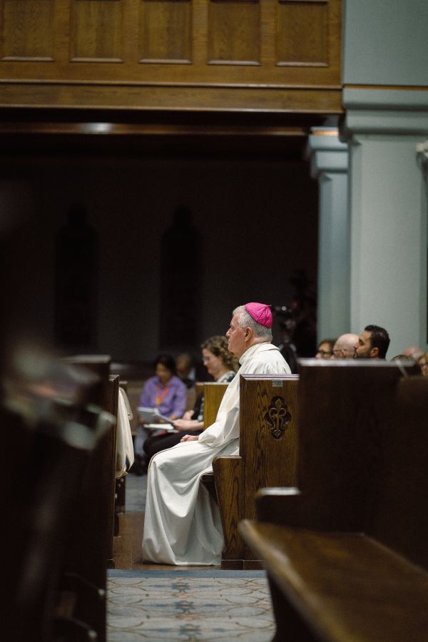 Calgary’s Bishop William McGrattan listens to the seven testimonies echoing the seven last words of Christ during the evening program. Credit: Edward Chan/Community Productions