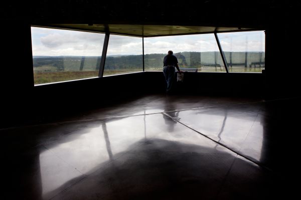An unidentified man looks through a window at the Flight 93 National Memorial Visitor Center near Shanksville, Pennsylvania, on Aug. 17, 2016. The window overlooks the impact site. Credit: Mark Van Scyoc/Shutterstock