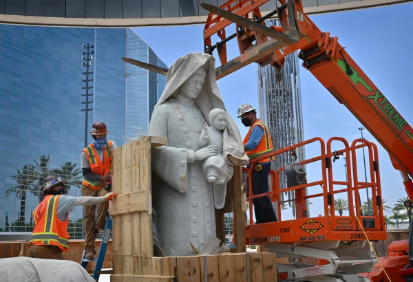 Crews carefully cut away at the box holding Christ Cathedral’s Our Lady of La Vang statue on June 2, 2021. It took three days to install the Italian marble statue, which weighs an estimated 16,000 pounds and, together with a cloud and base, is 18 feet tall. Credit: Steven Georges/Diocese of Orange