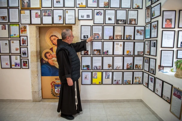 Father Luis Enrique Segovia points to some letters hanging on the wall of the friars' office, adjacent to the Milk Grotto in Bethlehem, which testify to the birth of a child attributed to the intercession of Our Lady of the Milk Grotto. Credit: Marinella Bandini