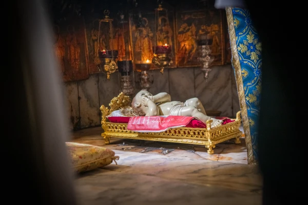 The statue of the Baby Jesus rests on the silver star in the Grotto of the Nativity in Bethlehem at the end of the Christmas Eve Mass on Dec. 24, 2024. Credit: Marinella Bandini