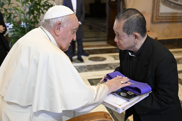 Pope Francis blesses a clergy stole while meeting with members of the Filipino community at the Vatican's Consistory Hall on Monday, Dec. 16, 2024. Credit: Vatican Media