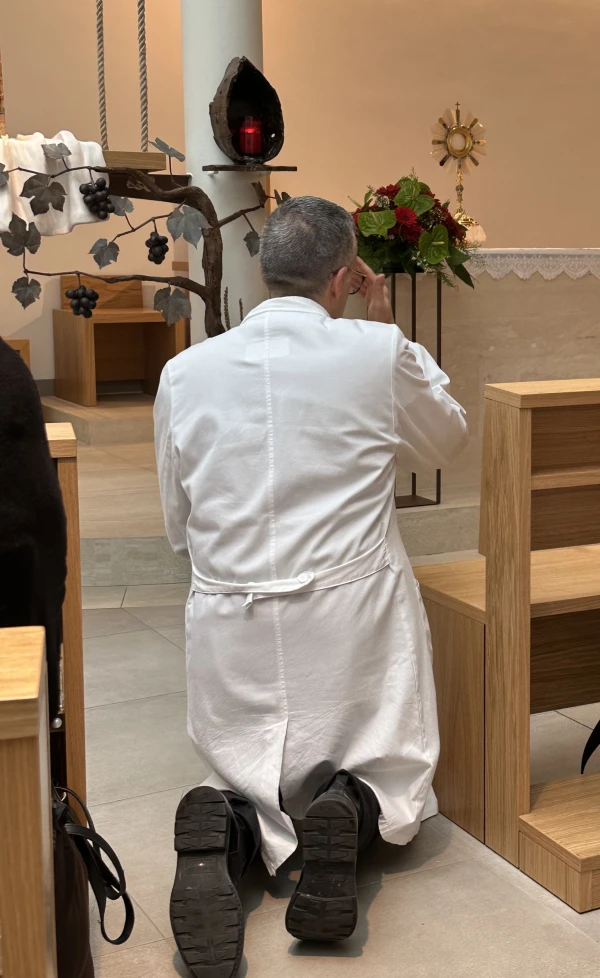 A doctor kneels and makes the sign of the cross before the Blessed Sacrament on Feb. 25, 2025, in the John Paul II Chapel at Gemelli Hospital in Rome, where Pope Francis is being treated for several health conditions. Credit: Courtney Mares/CNA