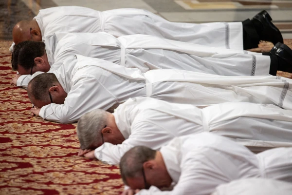 Deacon candidates lie prostrate during their ordination ceremony at St. Peter's Basilica, Feb. 23, 2025. Credit: Daniel Ibáñez/CNA