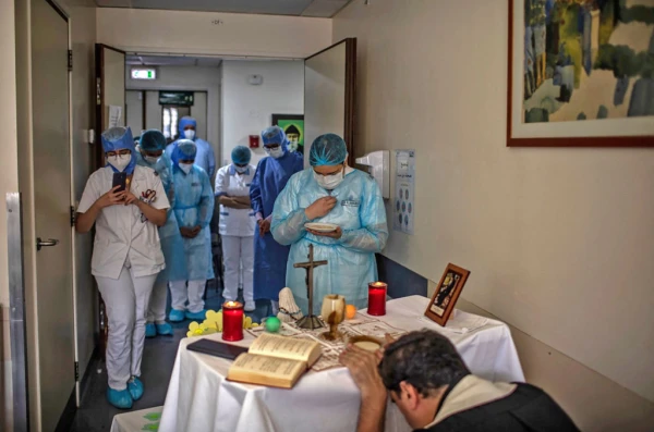 Health care staff attend Mass at the Hotel Dieu de France Hospital on May 8, 2020, in the COVID-19 section of the hospital located in the eastern suburbs of Beirut, Labanon. Credit: Hotel Dieu de France Hospital/AFP via Getty Images