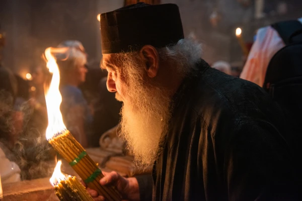 A Greek Orthodox priest holds a bundle of candles at the Basilica of the Holy Sepulcher, the revered site of Jesus' burial and resurrection in Jerusalem's Old City, on May 4, 2024, during the "Holy Fire" ceremony held on the day before the Orthodox Christian celebration of Easter. Credit: Marinella Bandini/CNA
