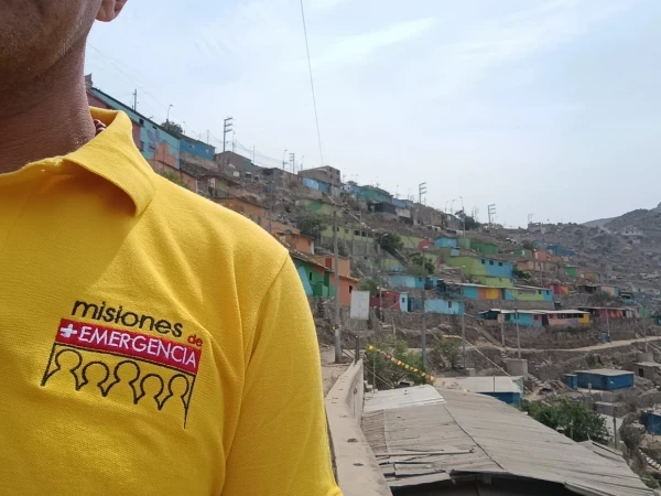 Emergency Missions T-shirt. In the background, a low-income neighborhood on a hill in Lima. Credit: Photo courtesy of Fabrizio Caciano