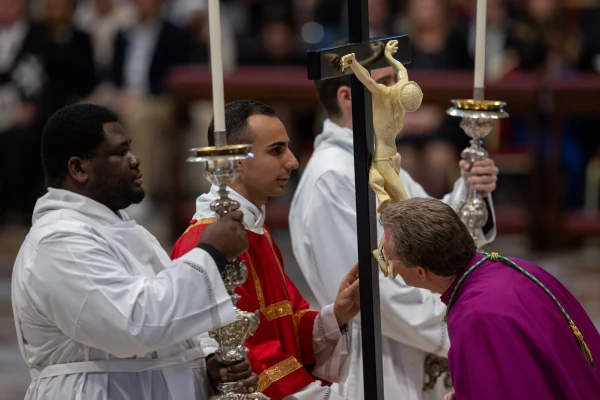 A priest in attendance at the Good Friday liturgy in St. Peter’s Basilica venerates the cross on April 18, 2025. Credit: Daniel Ibañez/CNA