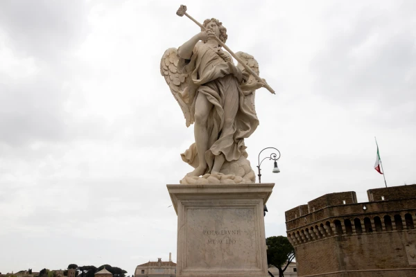 An angel bears the sponge used to give vinegar to the crucified Christ, with the inscription "Potaverunt me aceto" ("They gave me vinegar to drink") visible on its pedestal, with Castel Sant'Angelo in the background. Credit: Daniel Ibáñez/CNA