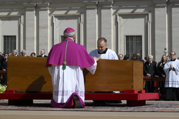 Archbishop Diego Giovanni Ravelli kneels next to the coffin holding the remains of Pope Francis during the funeral Mass in St. Peter's Square on Saturday, April 26, 2025. Credit: Vatican Media