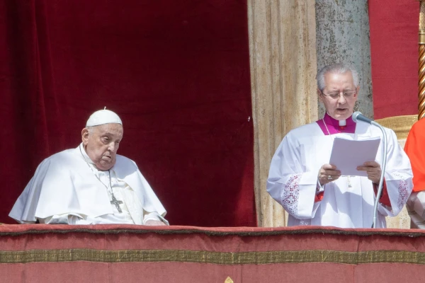 Archbishop Diego Ravelli reads the Easter message "urbi et orbi" as Pope Francis listens from the central loggia of St. Peter's Basilica, April 20, 2025. Credit: Daniel Ibáñez/CNA