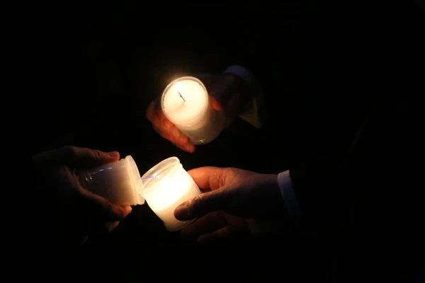Mass-goers light candles at the Easter Vigil Mass at St. Peter's Basilica, Saturday, April 19, 2025. Credit: Zosia Czubak
