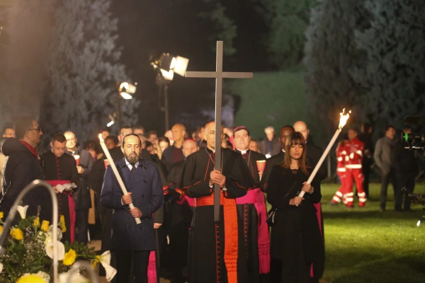 Cardinal Baldassare Reina carries the cross at the Via Crucis procession in Rome on April 18, 2025, accompanied by torch-bearing attendants, as he leads the first station representing "Jesus is condemned to death.". Credit: Zofia Czubak / EWTN News