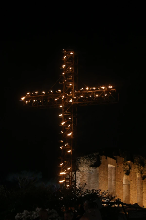 The illuminated cross stands against the night sky overlooking Rome's Colosseum during the Good Friday Way of the Cross ceremony that featured Pope Francis's reflections on God's economy versus today's world of algorithms. Credit: Zofia Czubak / EWTN News