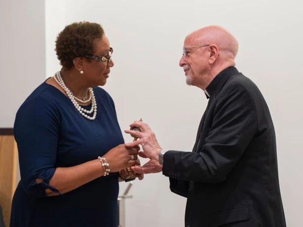 Father Thomas McClain, SJ, superior of the Detroit Jesuit community, presents Deborale Richardson-Phillips, president of Loyola High School, with a relic of St. Ignatius of Loyola, founder of the Society of Jesus, as a reminder to the school "to look to Christ as the model to follow," he said. Credit: Valaurian Waller/Detroit Catholic