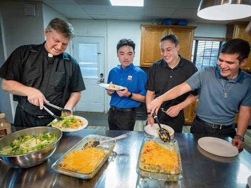 At the Nazareth House, meals are cooked by seminarians, which ensures they learn essential life skills within formation and become fully integrated into the running of the seminary. Here, seminarians are joined for dinner by Father Chauncey Winkler, a formator at the Nazareth House. Credit: Mike McCleary/University of Mary