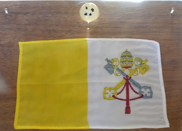 A small Vatican flag brought to the moon by Apollo astronauts in 1969, which now is displayed in the Vatican Museums. Above the flag are tiny moon rocks. Credit: Public domain