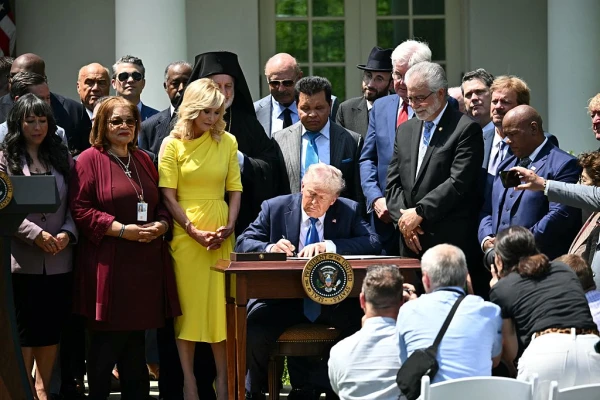 U.S. President Donald Trump, surrounded by faith leaders, signs an executive order on the “Establishment of the Religious Liberty Commission” during a National Day of Prayer event on May 1, 2025, in the Rose Garden of the White House in Washington, D.C. Credit: MANDEL NGAN/AFP via Getty Images