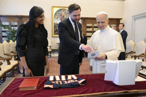 U.S. Vice President JD Vance and Second Lady Usha Vance show Pope Leo XIV the gifts they brought, including a Chicago Bears jersey with "Pope Leo XIV" printed on the back, during a private audience in the papal library on May 19, 2025. Credit: Vatican Media