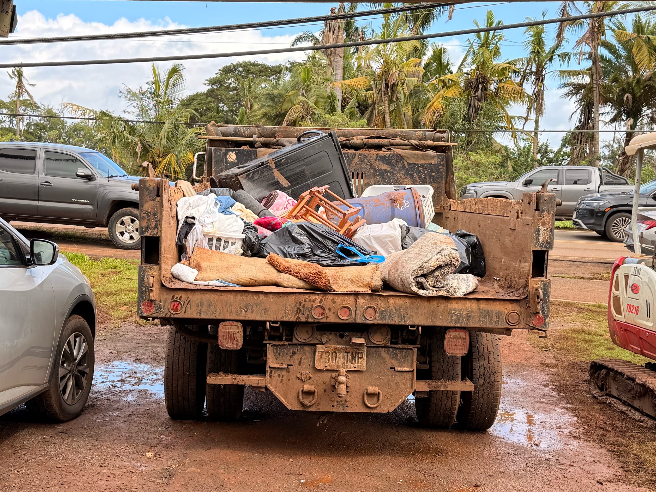 A truck carries away the soiled, muddy items homeowners are throwing away after torrential rains and winds destroyed homes and structures across Hawaii in March 2026. | Credit: Photo courtesy of Dallas Carter of EPIC Ministry