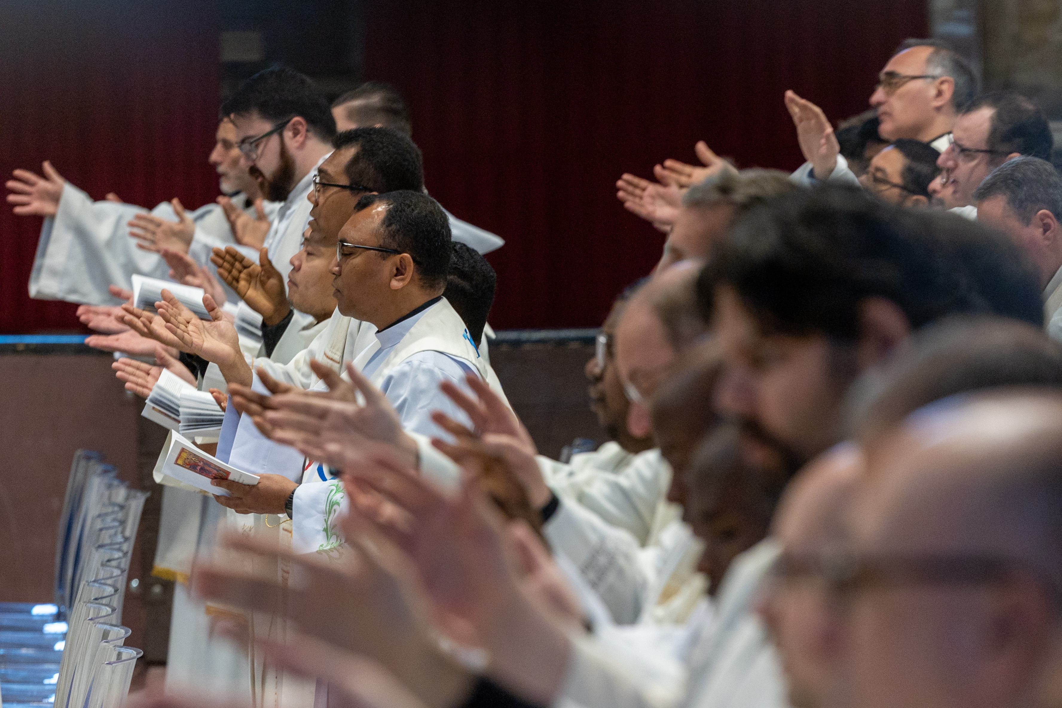 Clergy raise their hands in prayer during a chrism Mass at the Vatican on Holy Thursday, April 2, 2026. | Credit: Daniel Ibáñez/EWTN News