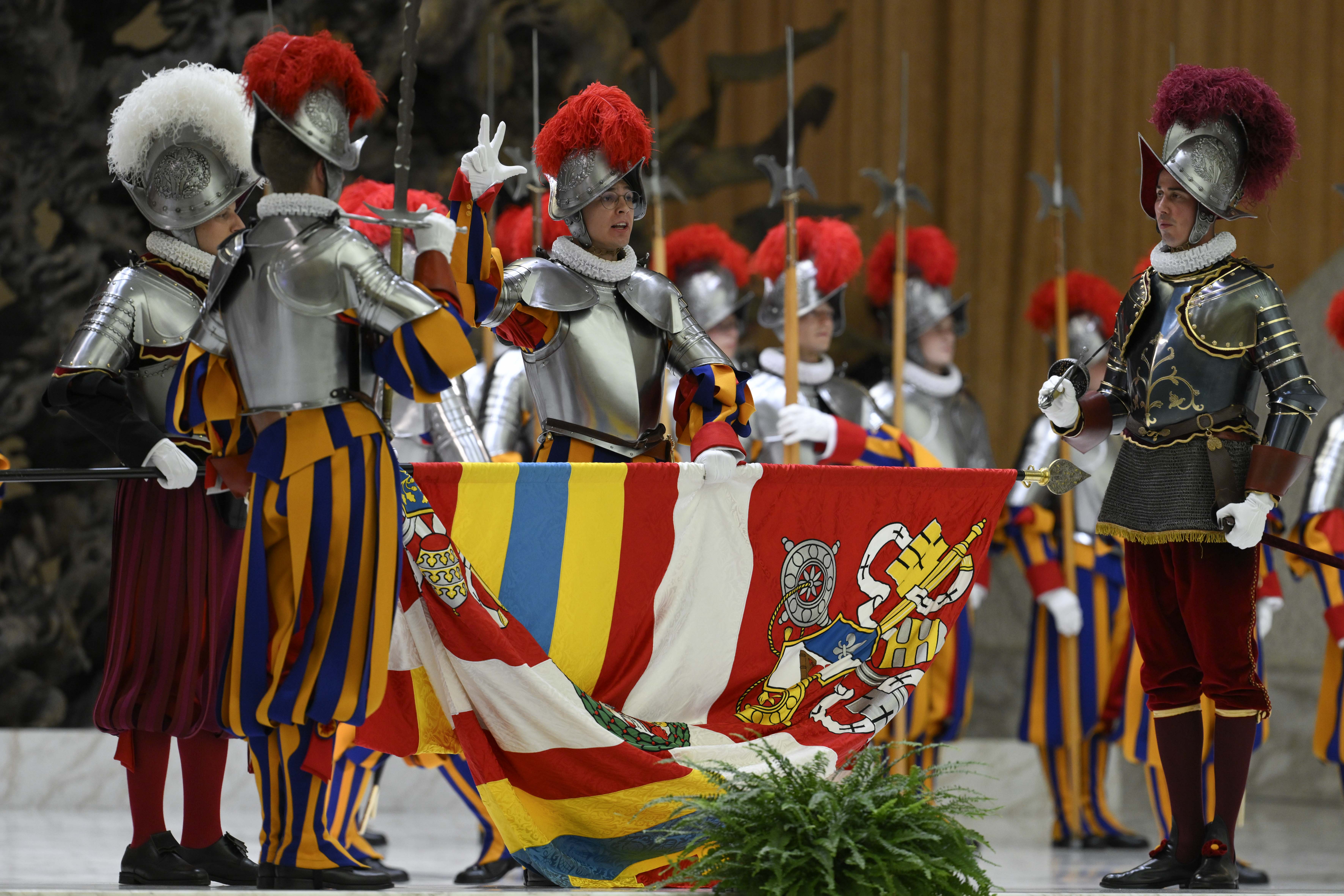 Each recruit holds the banner of the Pontifical Swiss Guard with his left hand, raises three fingers with his right, and recites the oath swearing to protect the pope, even at the cost of his life, on May 6, 2026. | Credit: Vatican Media