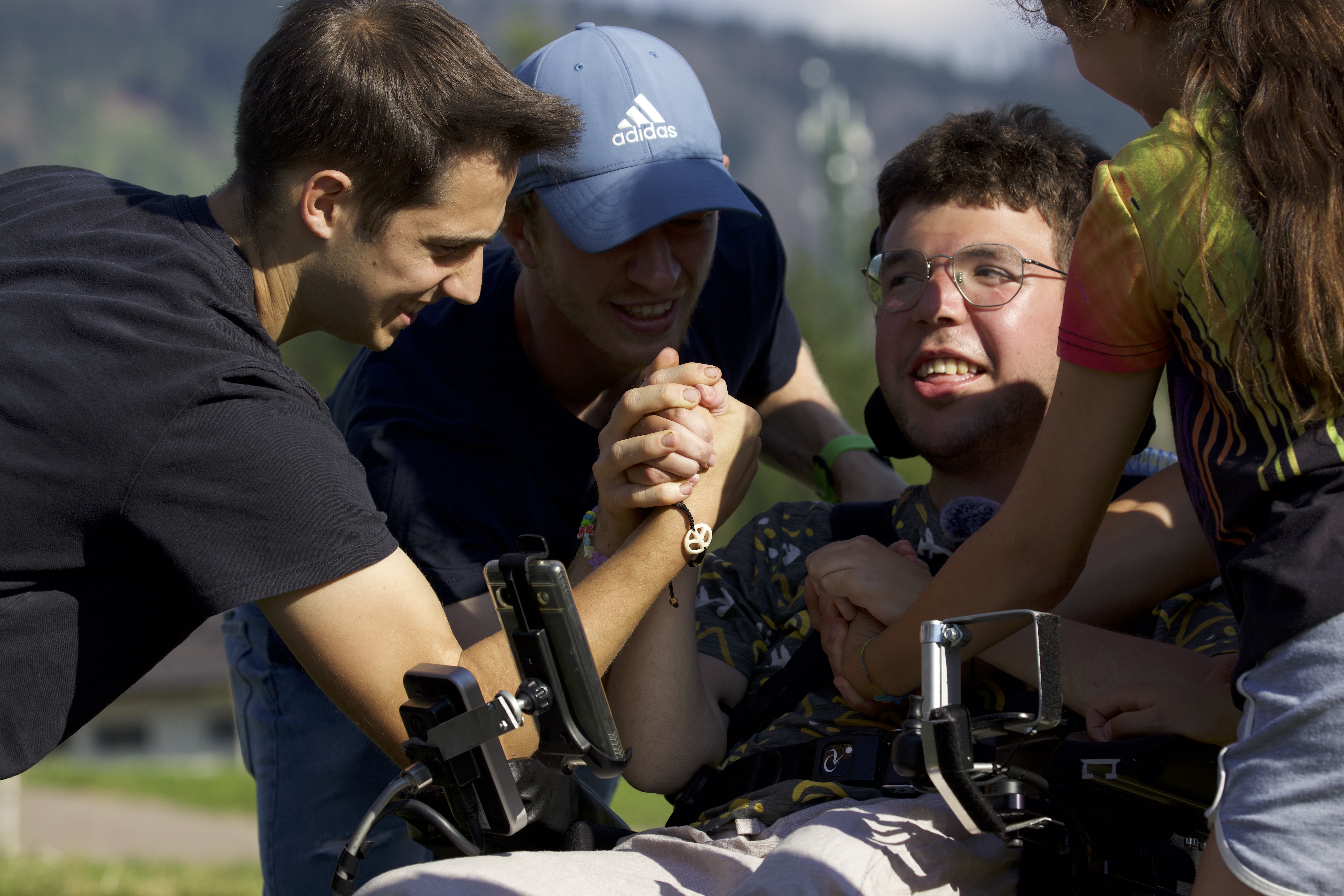 Giacomo Mattivi, a young Italian man with Duchenne muscular dystrophy, is surrounded by friends in a still from the film “Green Lava.” | Credit: Photo courtesy of “Green Lava”